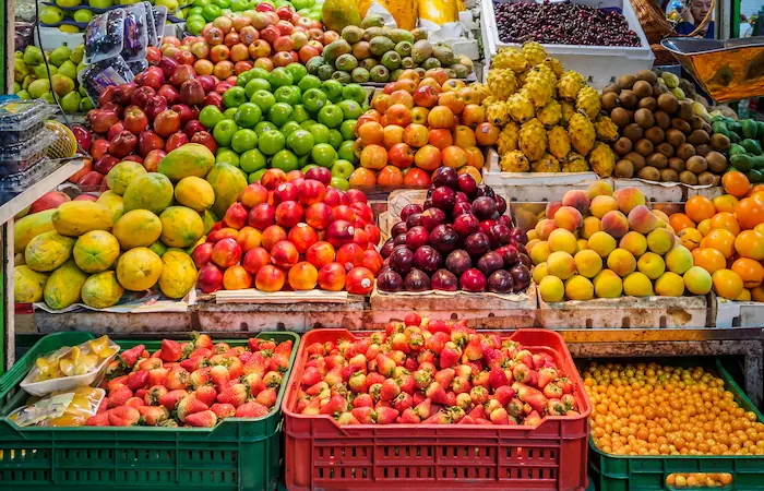 Photo of a fruit stand containing various fruit of varying colour.